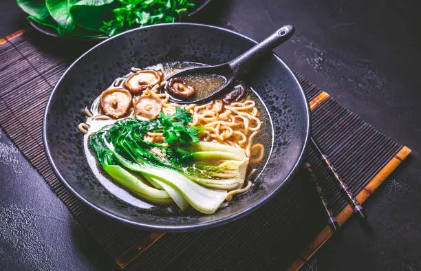 Freshly prepared vegan ramen soup, full of umami flavors with ramen noodles, shiitake mushrooms and steamed pak choi