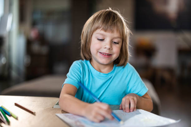 istock Happy little boy coloring with crayons at home. 1487437606