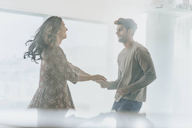 istock Young happy couple talking and dancing at home. 1487437740