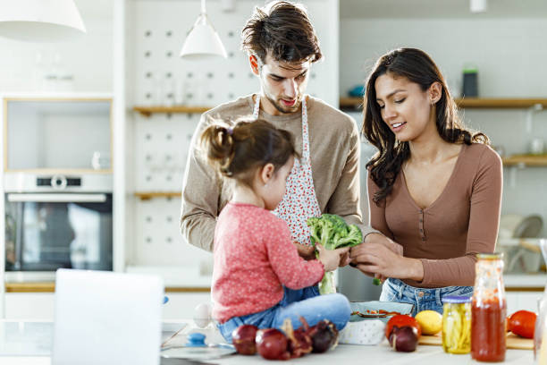 istock Young happy family making lunch in the kitchen. 1487437820
