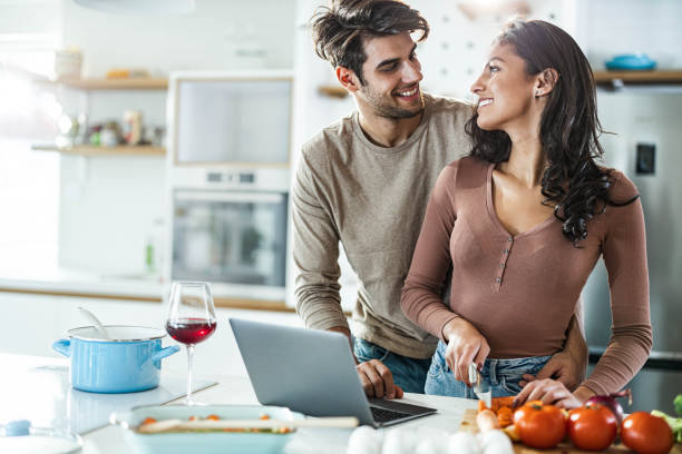 istock Young happy couple cooperating while preparing food in the kitchen. 1487438618