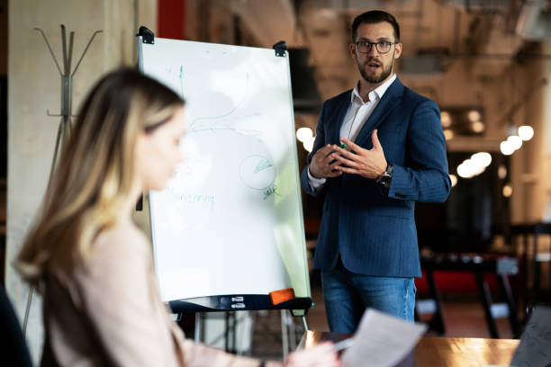 istock Businessman present his idea to working team. 1487438819