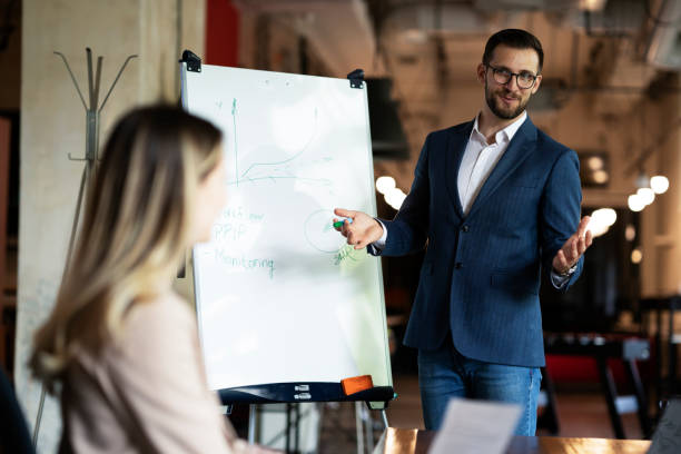 istock Businessman present his idea to working team. 1487438822