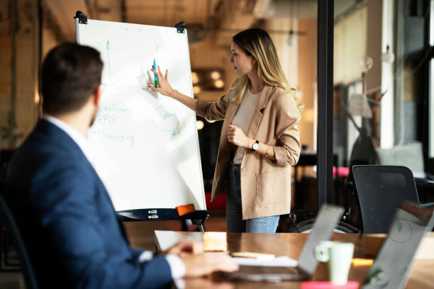 istock Businesswoman present her idea to working team. 1487438844