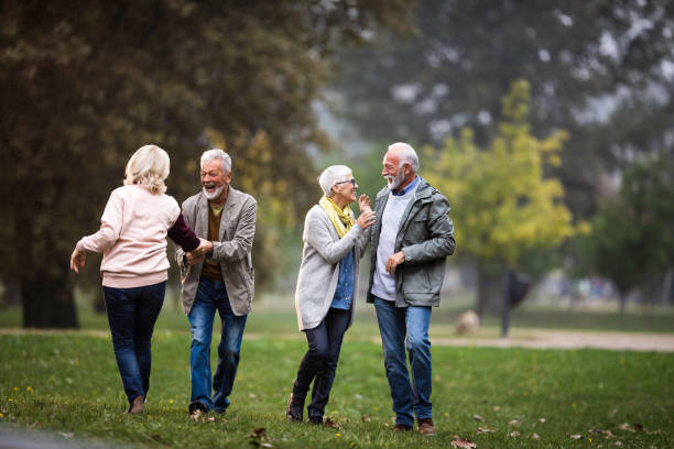 istock Cheerful senior couples having fun on a rain at the park. 1487438849