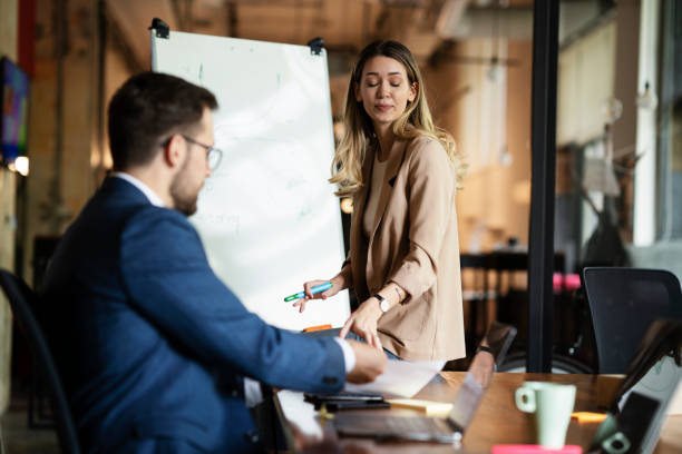 istock Businesswoman present her idea to working team. 1487438856