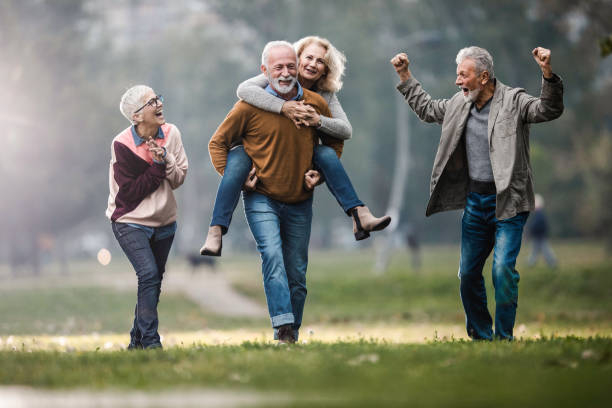 istock Playful mature couples having fun during autumn day in nature. 1487438893