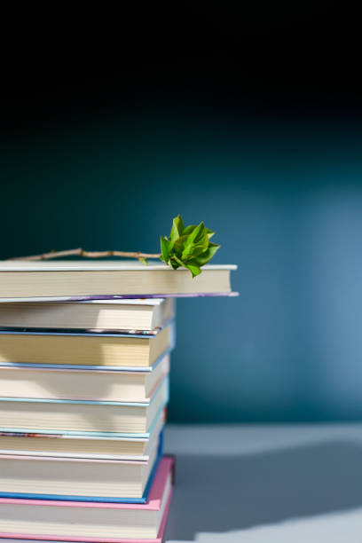 istock Stack of books with branch green leaves, World book day 1487440655