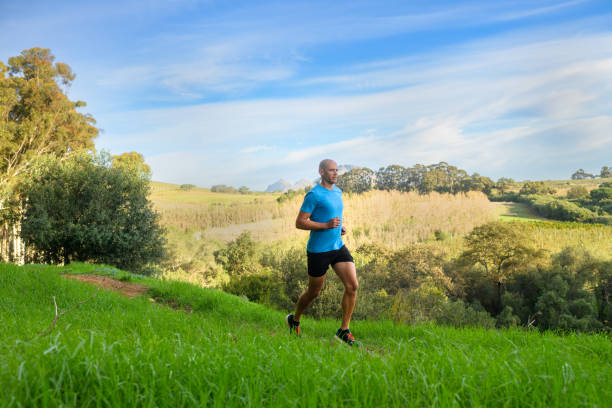 istock Side View Male Trail Runner running relaxed in country side 1487444626