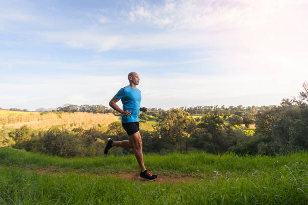 istock Side View Male Trail Runner jogging in country side 1487444725