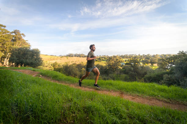 istock Side View Male Trail Runner running fast in country side 1487444844