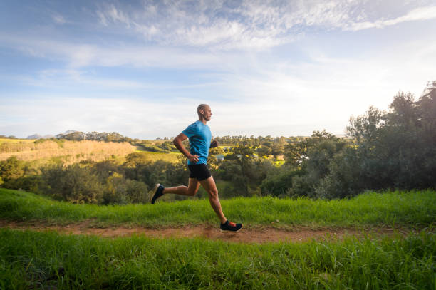 side view male trail runner de longues foulées rapides en campagne - track and field 30s adult athlete photos et images de collection