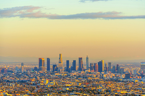 Beauty of the Los Angeles skyline at sunset. The city's iconic skyscrapers are silhouetted against the vibrant colors of the sky, creating a stunning urban landscape.