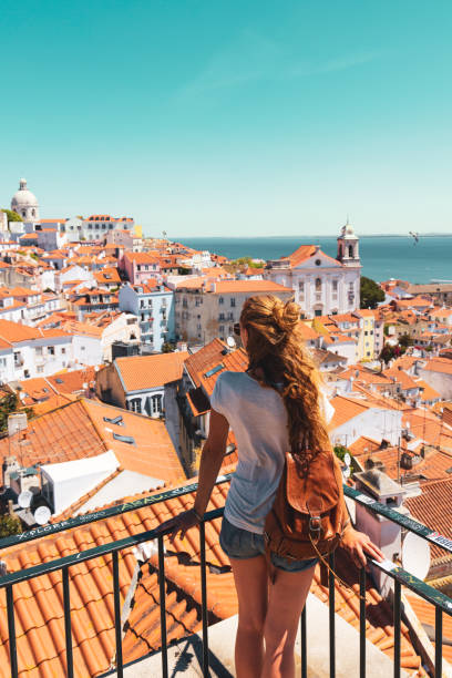 Traveler Woman, tourist on balcony looking at panoramic view of Lisboa- Tourism, vacation, travel in Portugal stock photo