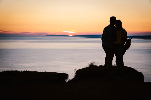 couple on cliff in ireland during sunset