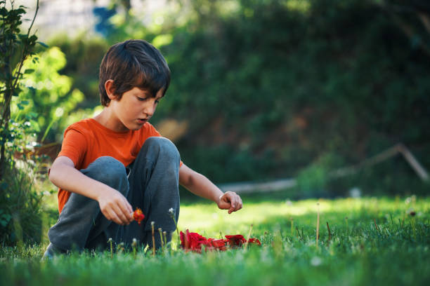 istock child playing with rose petals in the garden 1487449129