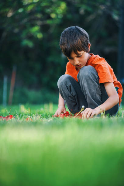child playing with rose petals in the garden