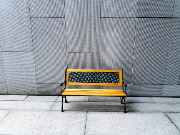 istock Modern yellow bench on white or gray concrete wall background with copy space 1487449379