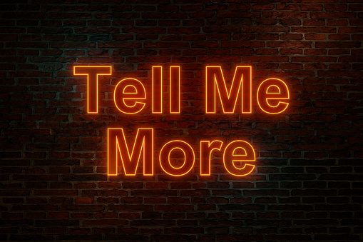 Brick wall at night with the text Tell Me More in orange neon letters. Asking, motivation, communication, feedback and inspiration. 3D illustration