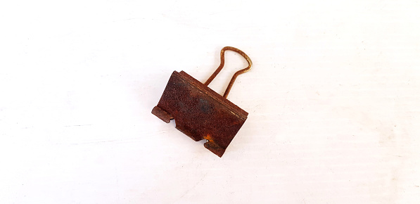Old Rusty paperclip putting or isolated on white board or background. Single object concept