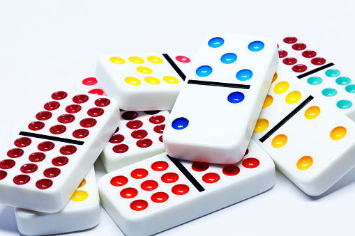 colorful dominoes lying in a pile on white background