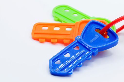 three plastic toy keys in different colors on a white background