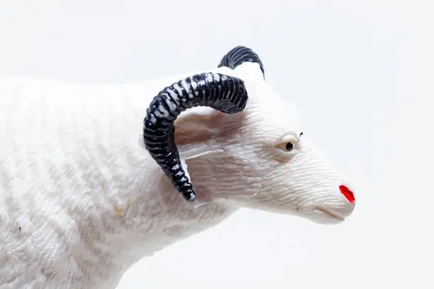 a white plastic toy depicting a goat