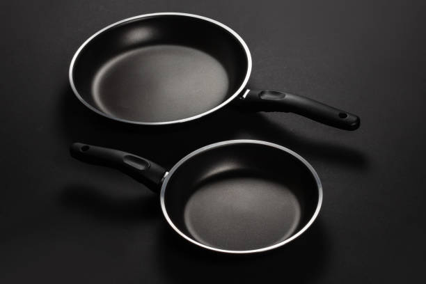 istock Two black frying pan on dark background, close-up, 1487456439