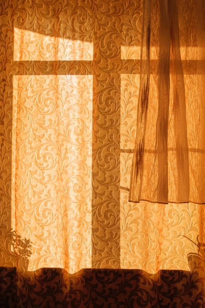 istock Bright sunlight breaks through a dense closed curtain of golden color 1487456570