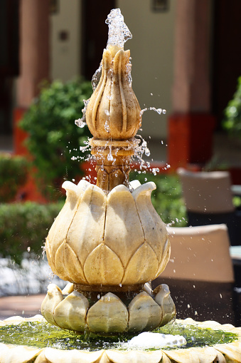 Stock photo showing close-up of fountain nozzle, water feature in garden.