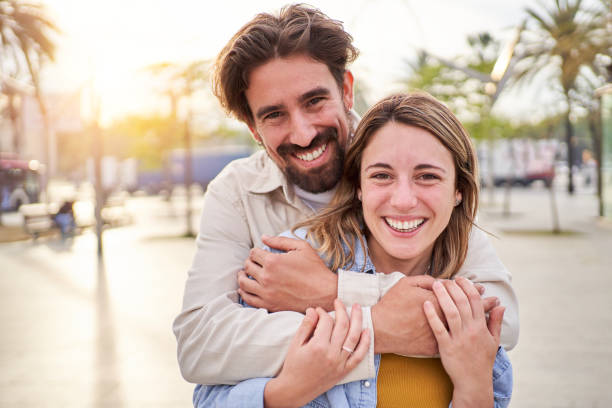 istock Caucasian couple looking at camera cheerfully while standing outdoors together. 1487460059