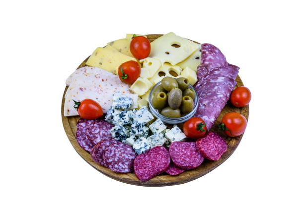 Slices of various types of cheese and dry smoked salami sausage isolated on a white background. Traditional italian antipasto platter stock photo