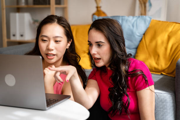 istock Two women using laptop in living room. 1487463552