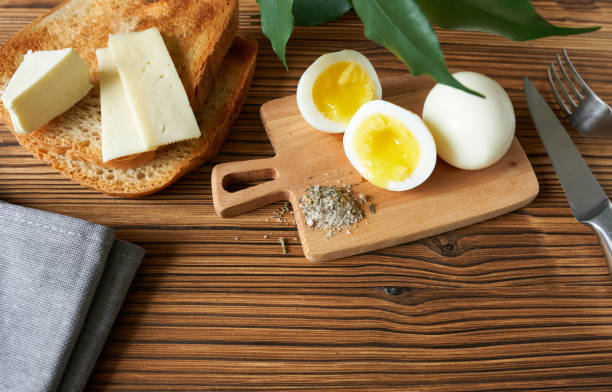 istock Eggs and cheese, toast with a cube of butter on a cutting board. 1487463621
