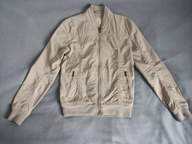 Beige light men's jacket on a gray background