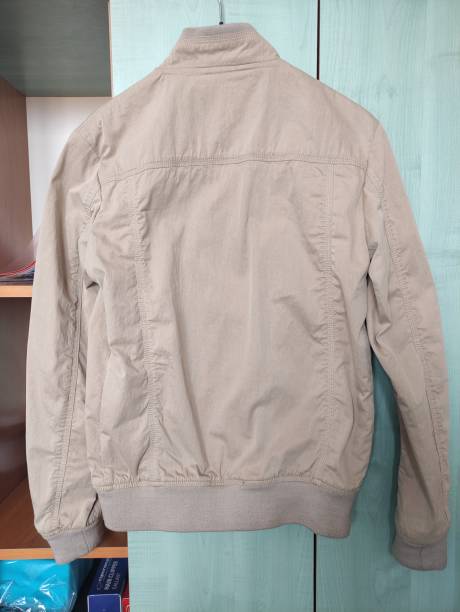 Beige light men's jacket on a hanger