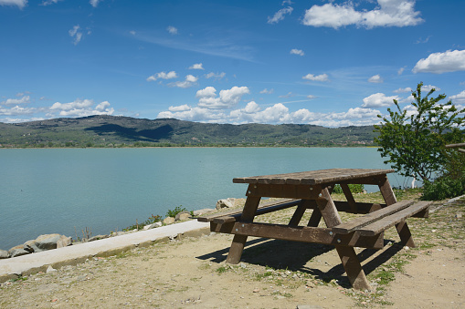 Table for eating together on a sunny day. In the background the Trasimeno lake. Umbria. Italy