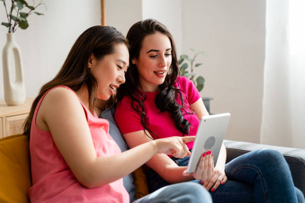 istock Women sitting in living room at home using digital tablet. 1487465001