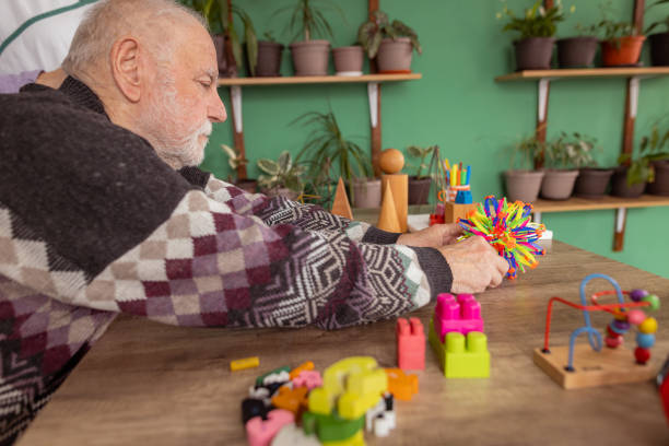 istock Senior man uses colorful toys for therapy 1487468066