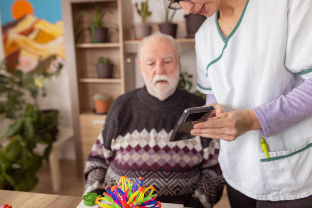 istock Nurse using mobile phone as part of therapy for dementia 1487468113