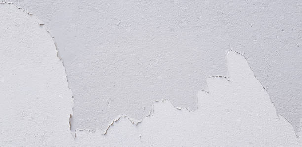 istock White painted cracked on gray cement wall for background 1487468937