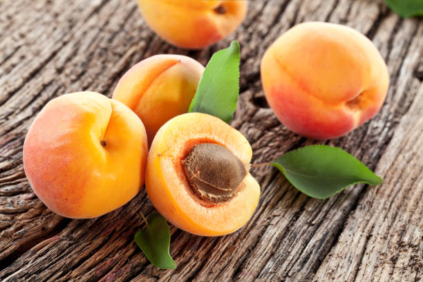 istock Ripe apricots on old wooden table. 1487469694