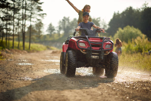 las chicas extremas montan quads en una carretera en la naturaleza. - car child teamwork sports race fotografías e imágenes de stock