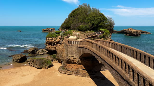 Stone bridge to the Rocher du Basta, the scenic rock and major landmark in the coast of Biarritz, France. High quality 4k footage