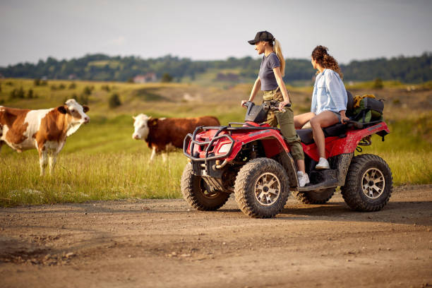 Two beautiful woman driving quad together; Active vacation concept