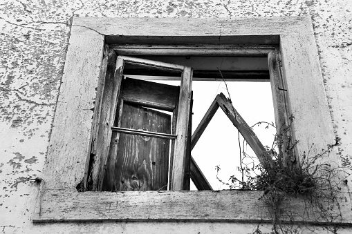 Broken and damaged window in an old house in Portugal