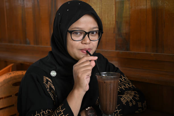 istock Asian woman drinking chocolate 1487477225