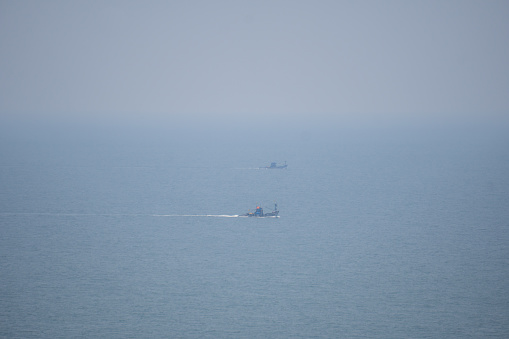 Closeup shot of boats in the Arabian sea at Goa in India. Boats as seen from the top of the hill in Goa. Fishing boats in the sea. Boats fishing in the Arabian sea.