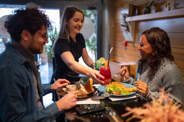 istock Waitress serving drinks to a multiracial couple in a restaurant 1487479014