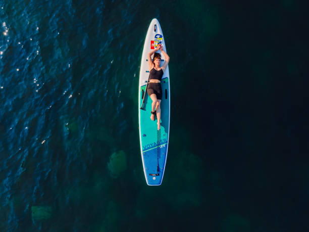 24. juli 2022. antalya, türkei. frau entspannt sich auf stand-up-paddle-board am blauen meer. erholung auf dem roten paddel-sup-board im meer. luftbild - editorial women paddleboard surfboard stock-fotos und bilder